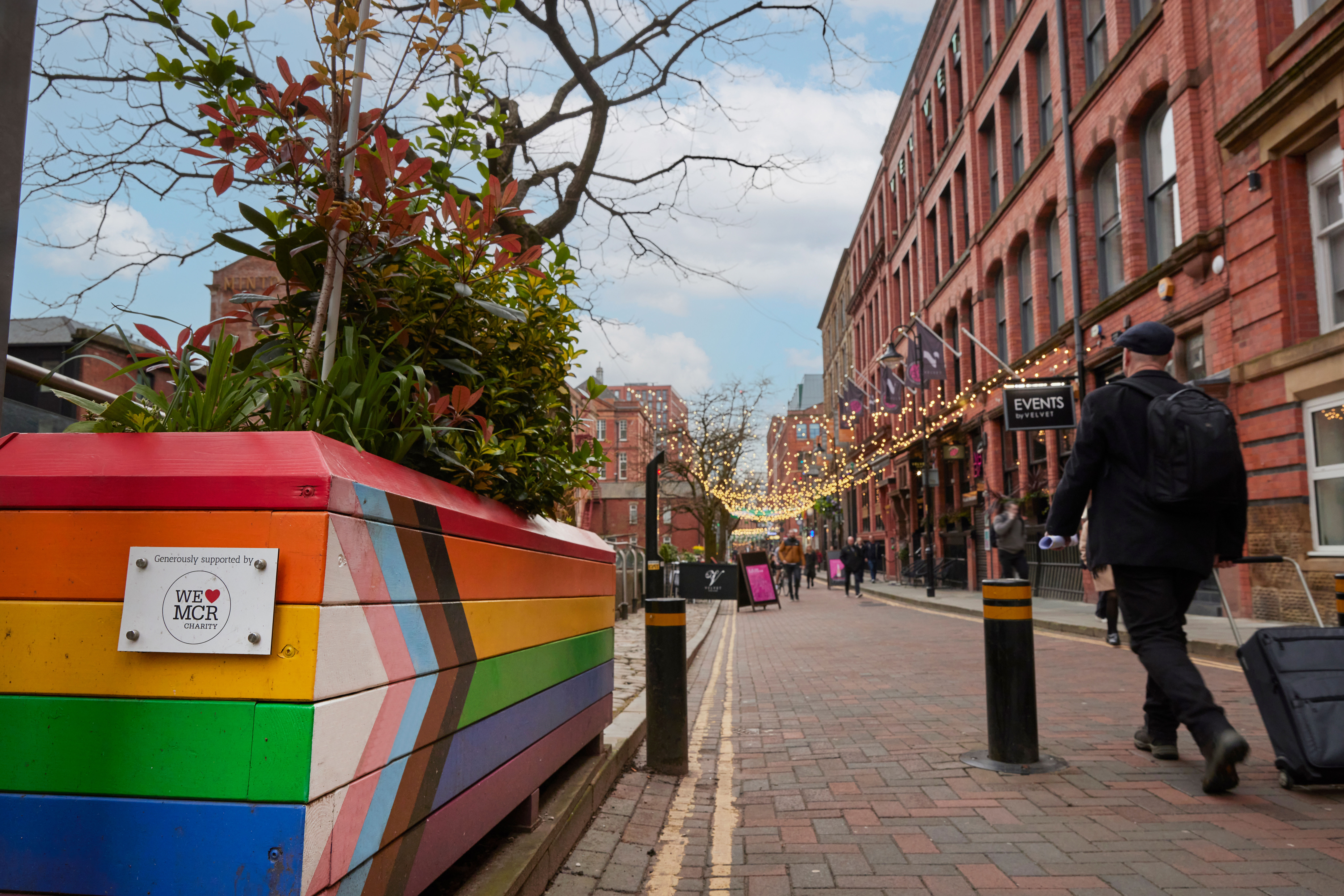 Pedestrians walking along a canal side shopping precinct.