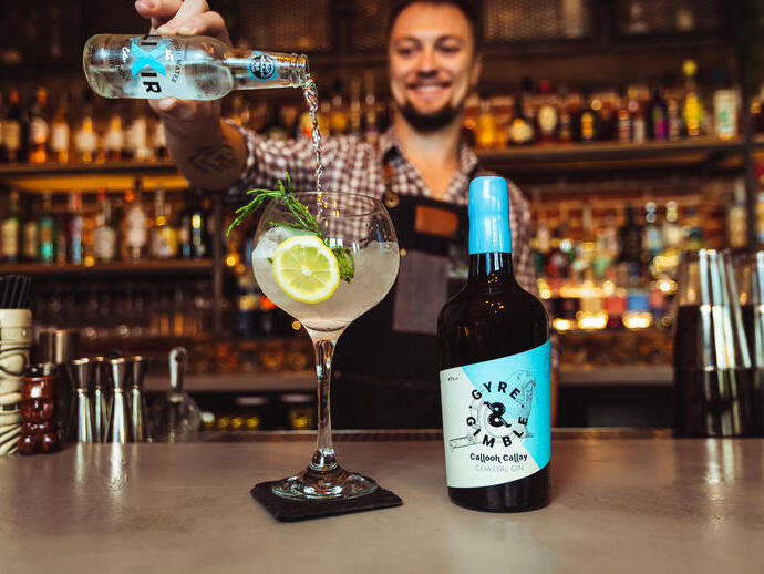 Un barista che versa un cocktail con gin costiero al Gyre & Gimble di Norwich