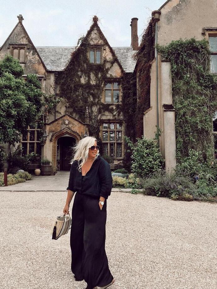 A woman stood outside The Pig Hotel in Combe, Devon