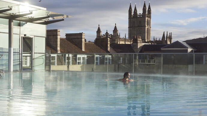 Woman in a roof top swimming pool at a spa