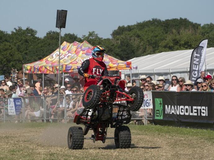 A quad bike doing a stunt in front of a crowd at the Royal Cheshire Show