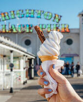 A woman holding an ice cream cone on a pier