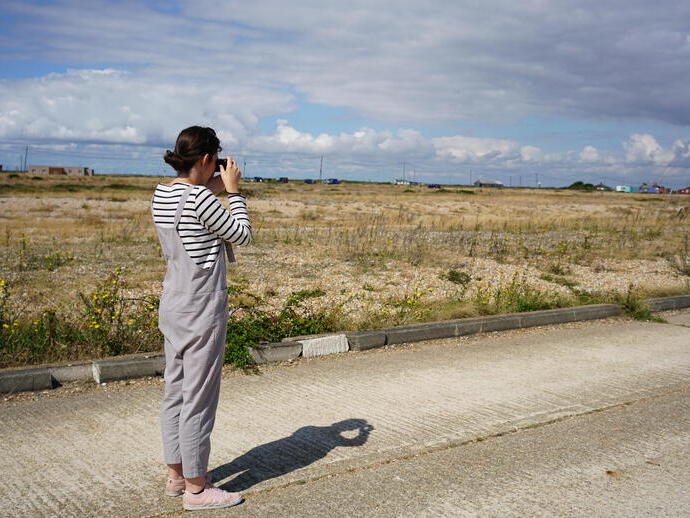 A female photographer in the Dungeness Landscape.