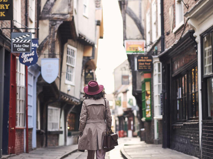 Femme marchant dans une rue historique étroite d'une ville