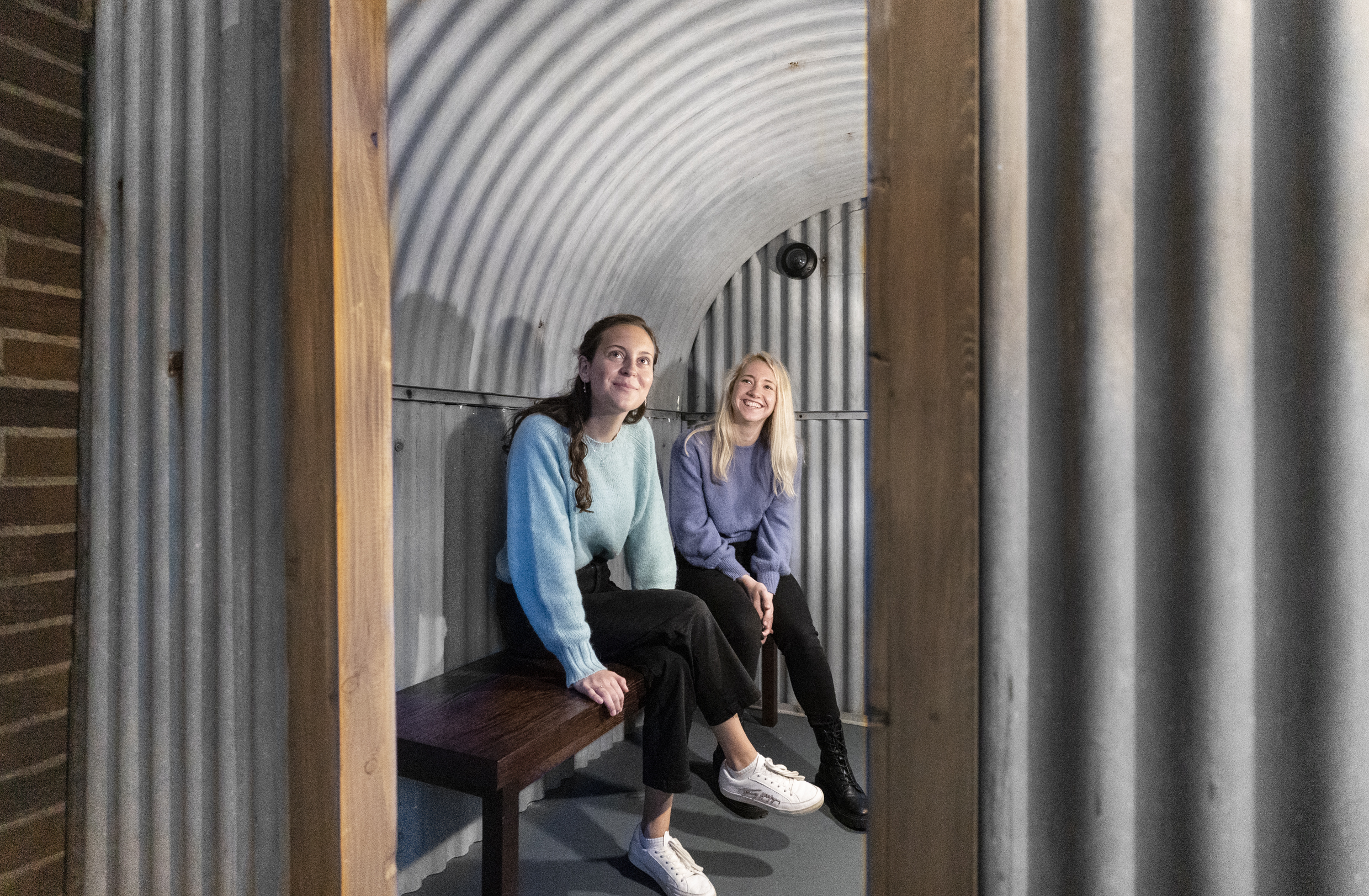 Two women sitting in a replica shelter in the Imperial War Museums, London