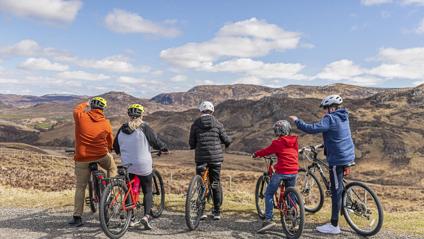 Group of people on bicycles looking at a valley