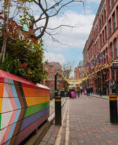 Pedestrians walking along a canal side shopping precinct.