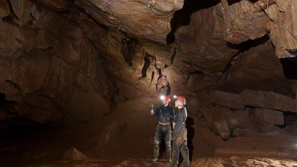 Dos personas practicando espeleología en las cuevas de Cheddar Gorge