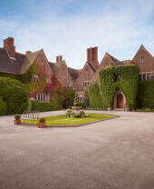 The front entrance, driveway and manicured gardens of a county hotel and spa.