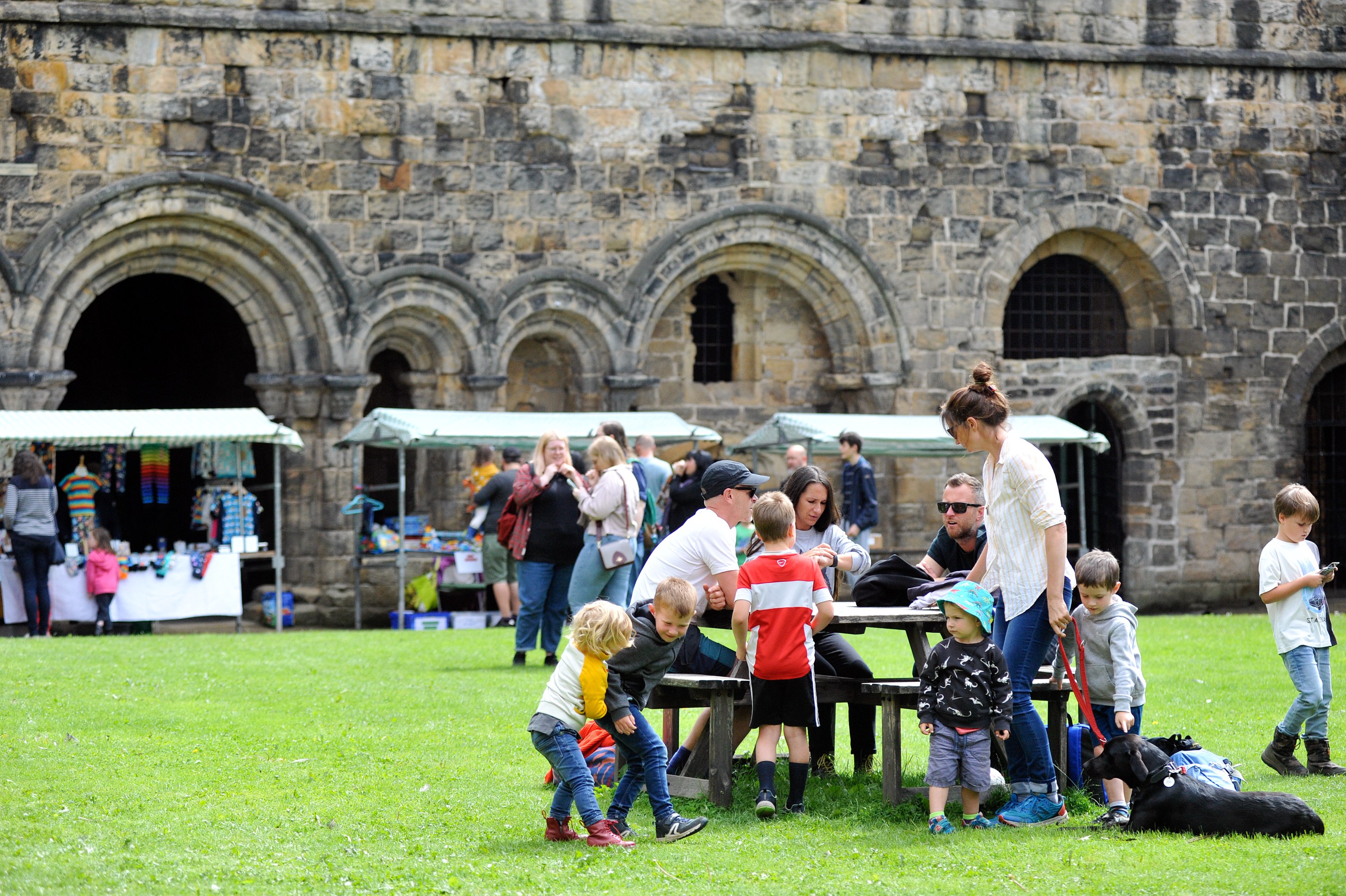 Groups of people eating and shopping outside Kirkstall Abbey