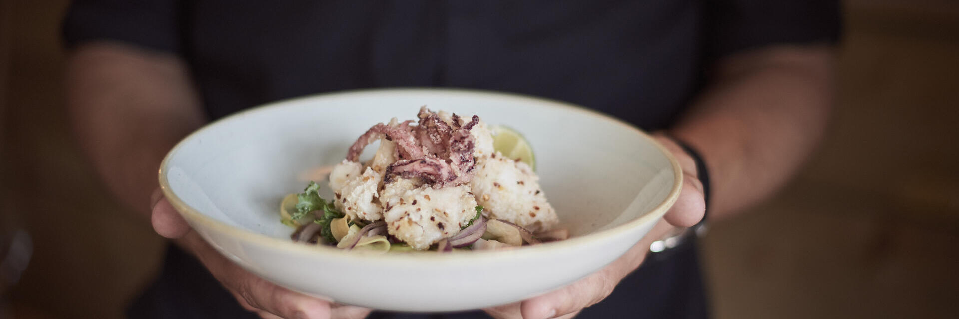 لقطة مقربة لشخص يحمل طبقًا به طعام.