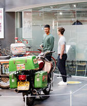 Dos hombres mirando una exposición de motocicletas en un museo.