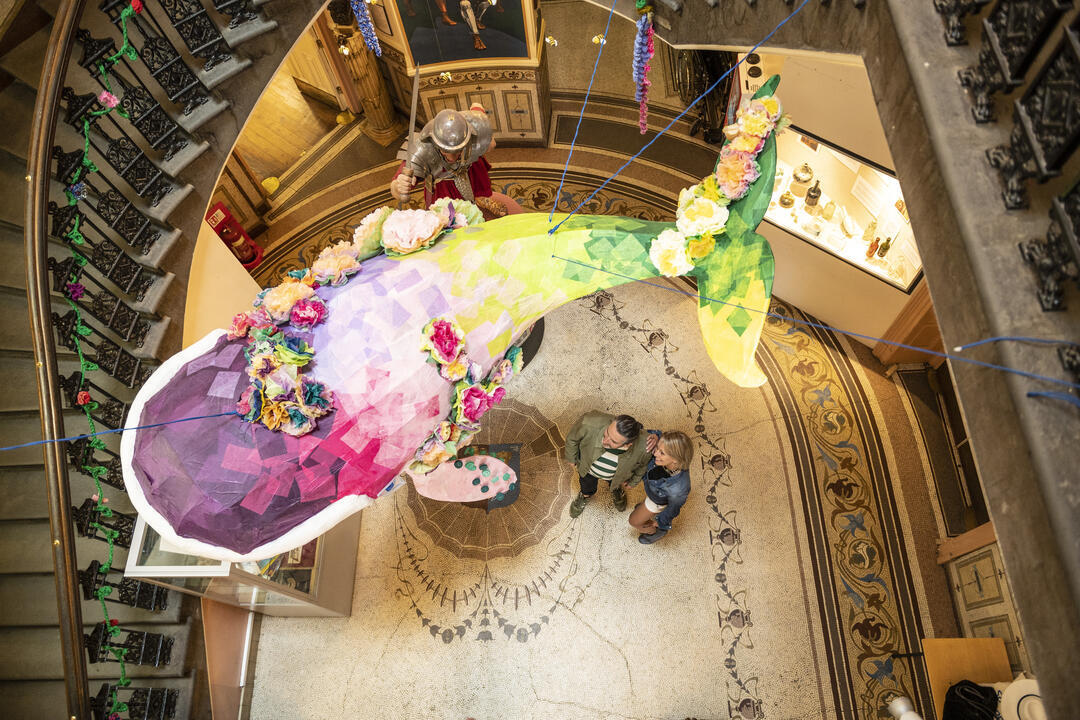An art exhibit hanging above two people at the Grosvenor Museum in Chester