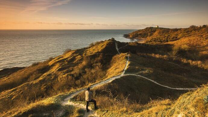 Man standing on coastal path near the sea