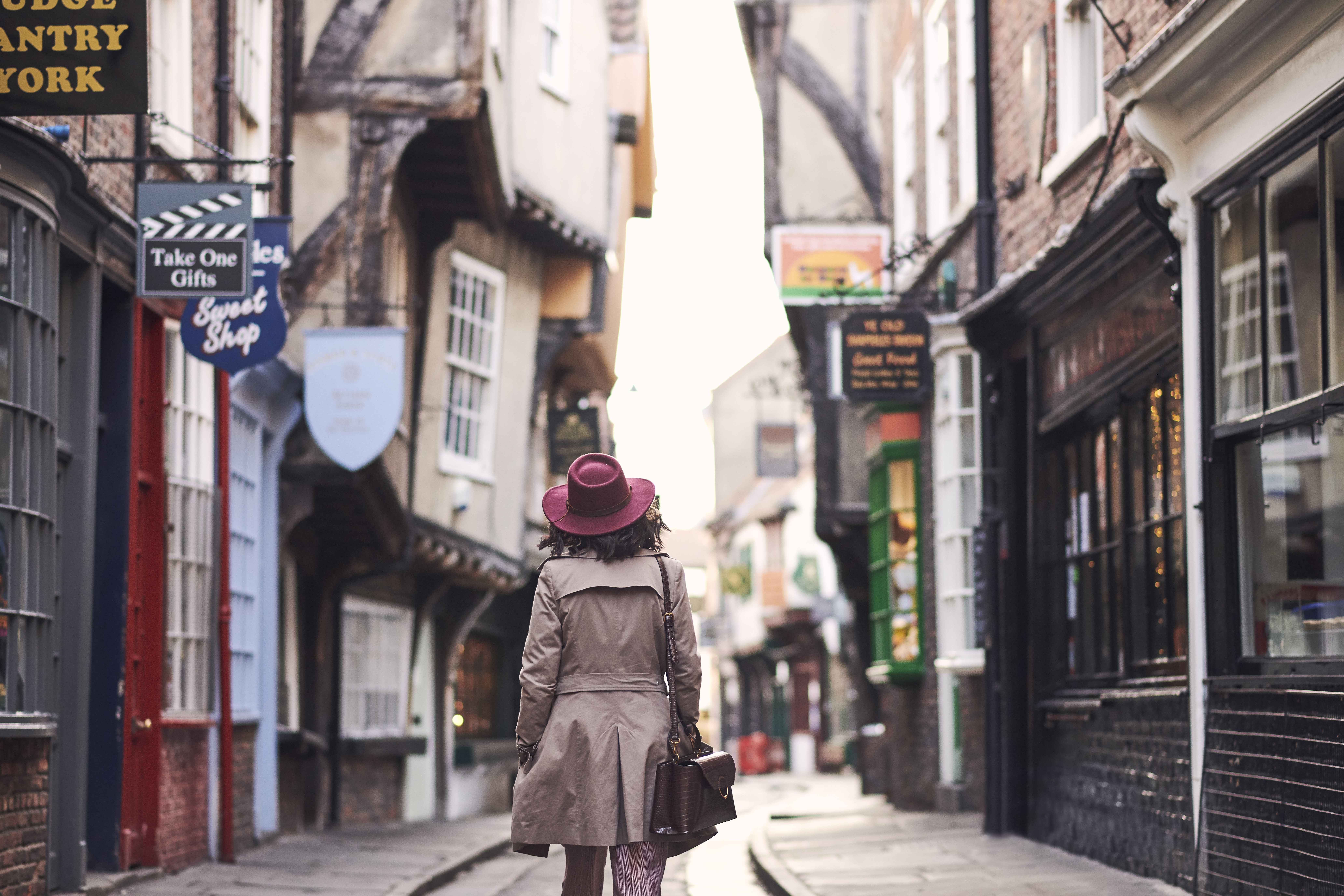 Woman walking through a narrow historic street in a city