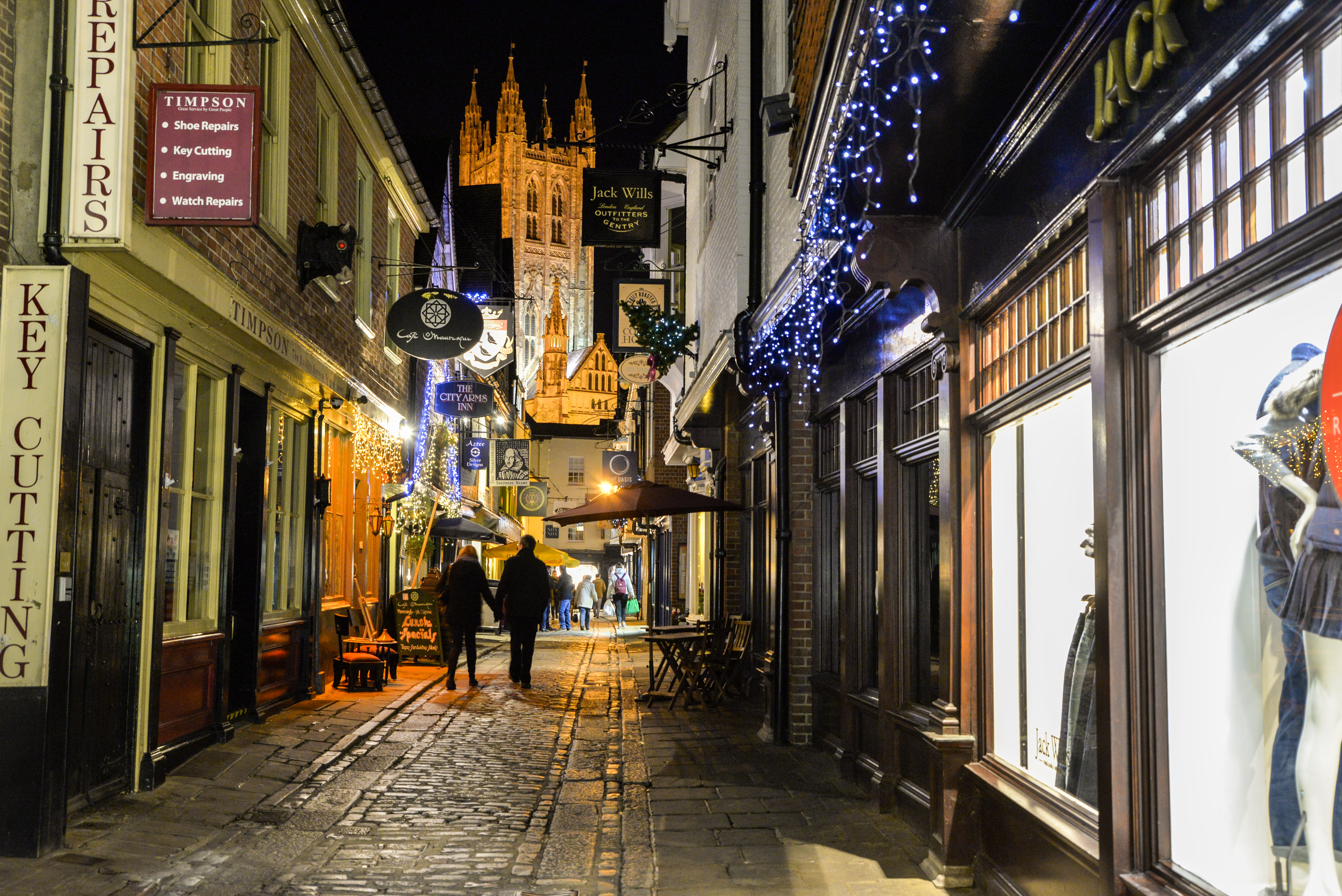 Man and woman walking along a street at night