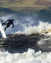 Un surfista cabalgando las olas frente a la costa del Reino Unido
