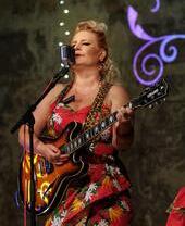 Una signora che canta e suona la chitarra alla Wilton's Music Hall