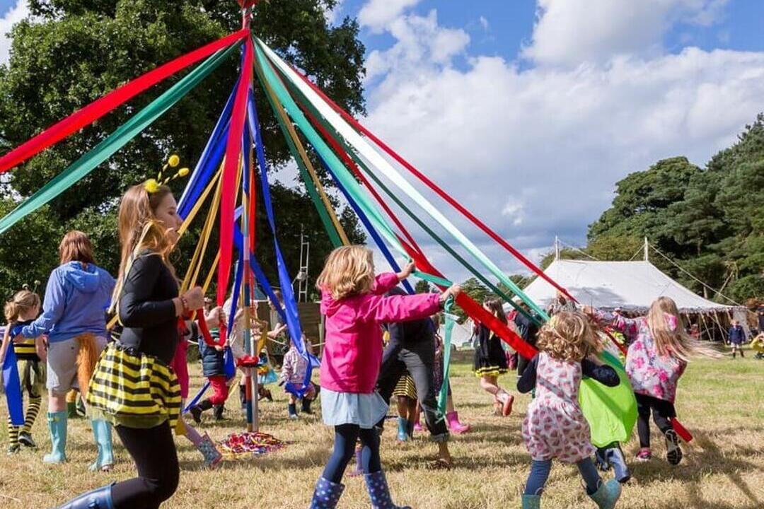 A group of children dancing around a maypole at Hever Castle