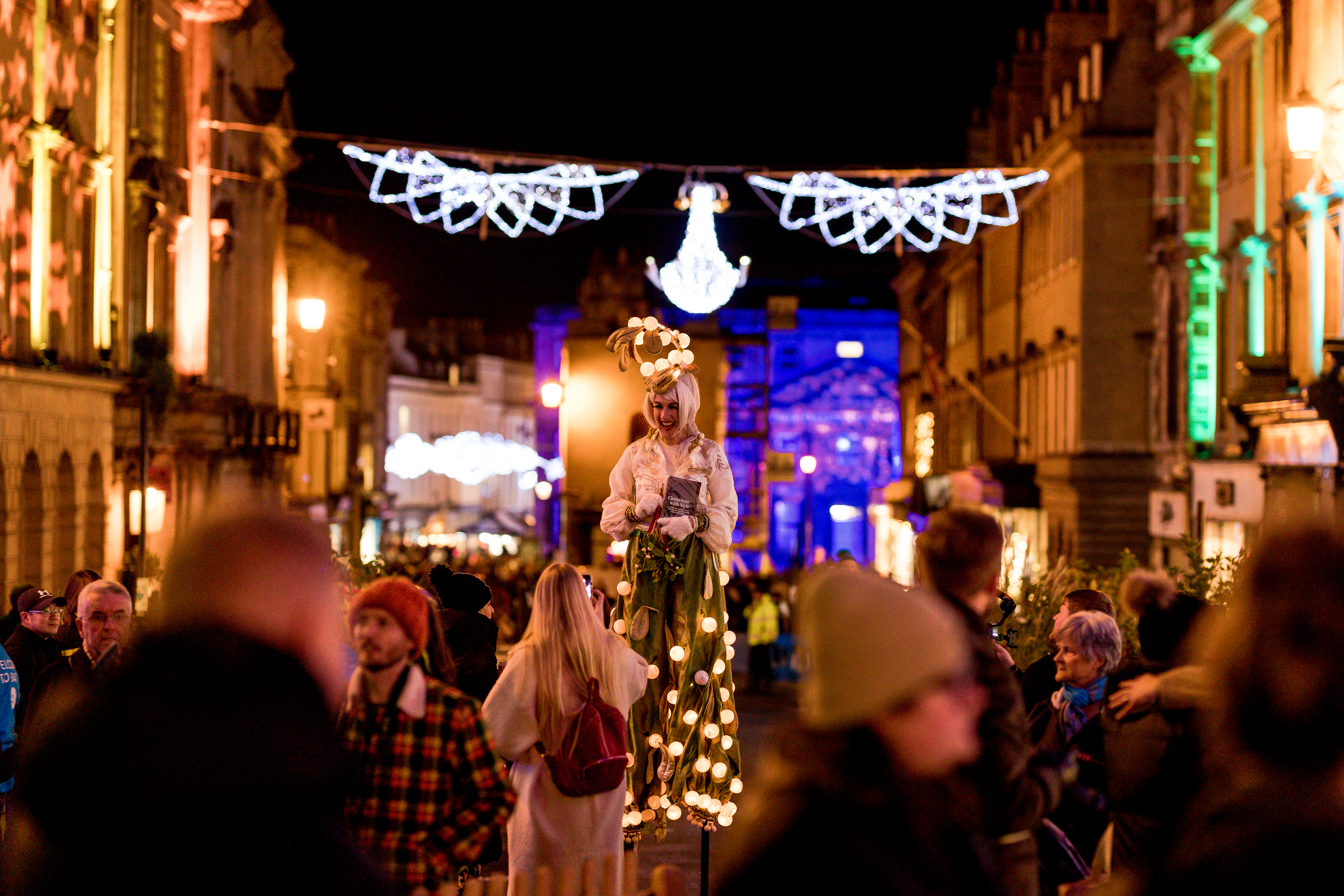 Un artiste de rue sous les lumières de Noël dans la rue principale de Bath