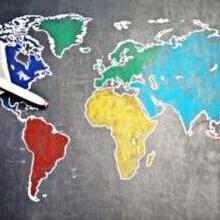 Hand pushing plane model over image of world countries