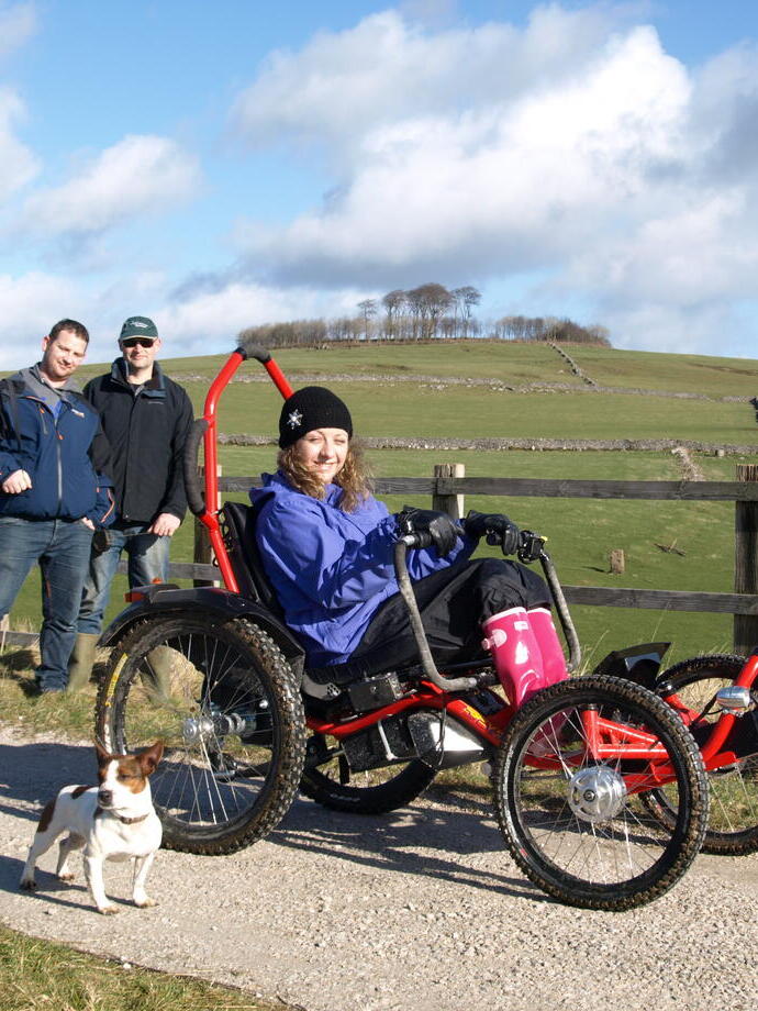 A guest using an accessible four-wheel bike at Hoe Grange Holidays, Derbyshire
