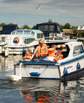 A family riding on a boat in the Norfolk Broads