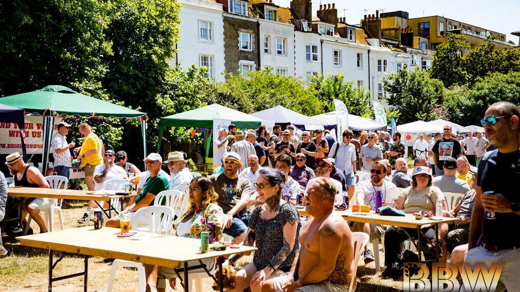 A group of people sat in the sun at Brighton Bear Weekend, a popular LGTBQ+ festival