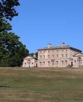 View of a large country house surrounded by trees