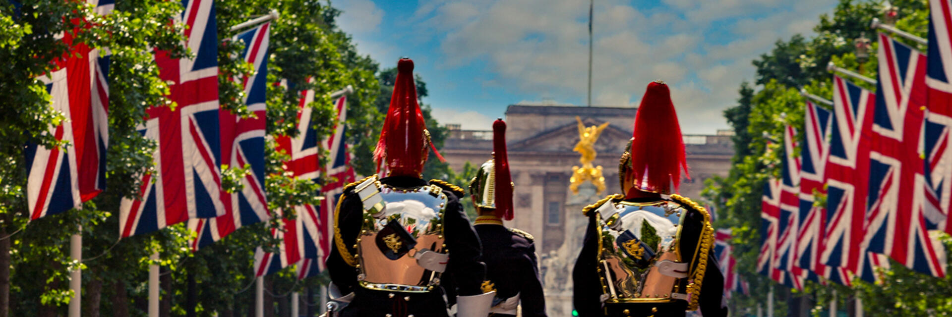 Guardie militari a cavallo tra file di bandiere dell'Union Jack