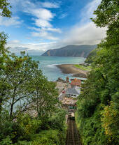 A steep railway heading down to a beach, overlooking an expansive pretty ocean.