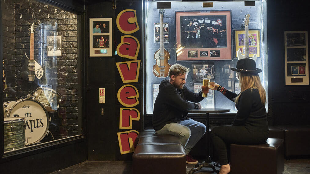 Man and woman sat in a music club having a drink