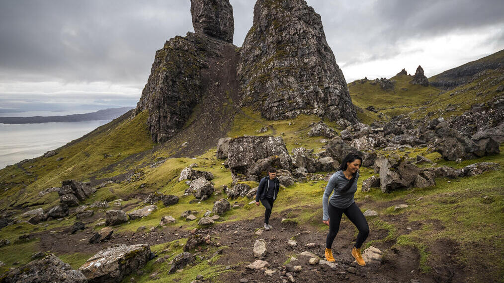 Pareja haciendo senderismo cerca de pináculos de basalto