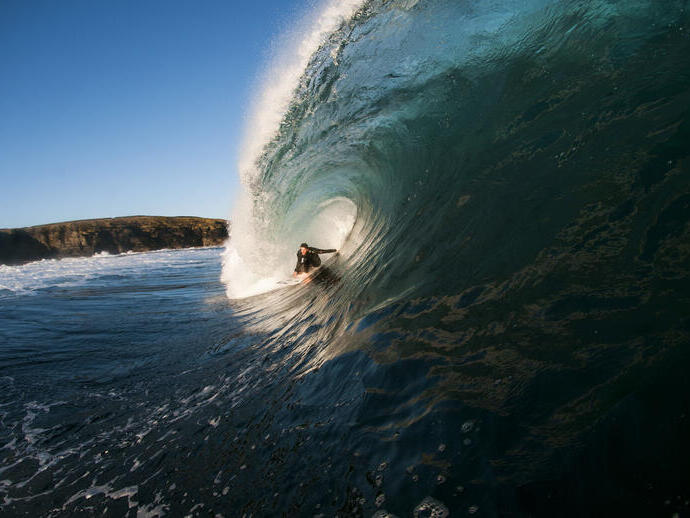 Homme surfant sur une vague géante dans la mer