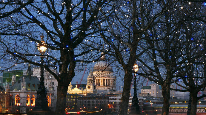 Silhouette nocturne de la ville avec une cathédrale à coupole et d'autres bâtiments éclairés dans les arbres