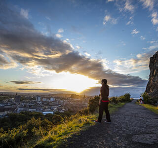 Uomo che ammira la vista panoramica di Edimburgo dalla cima dell'Arthur's Seat