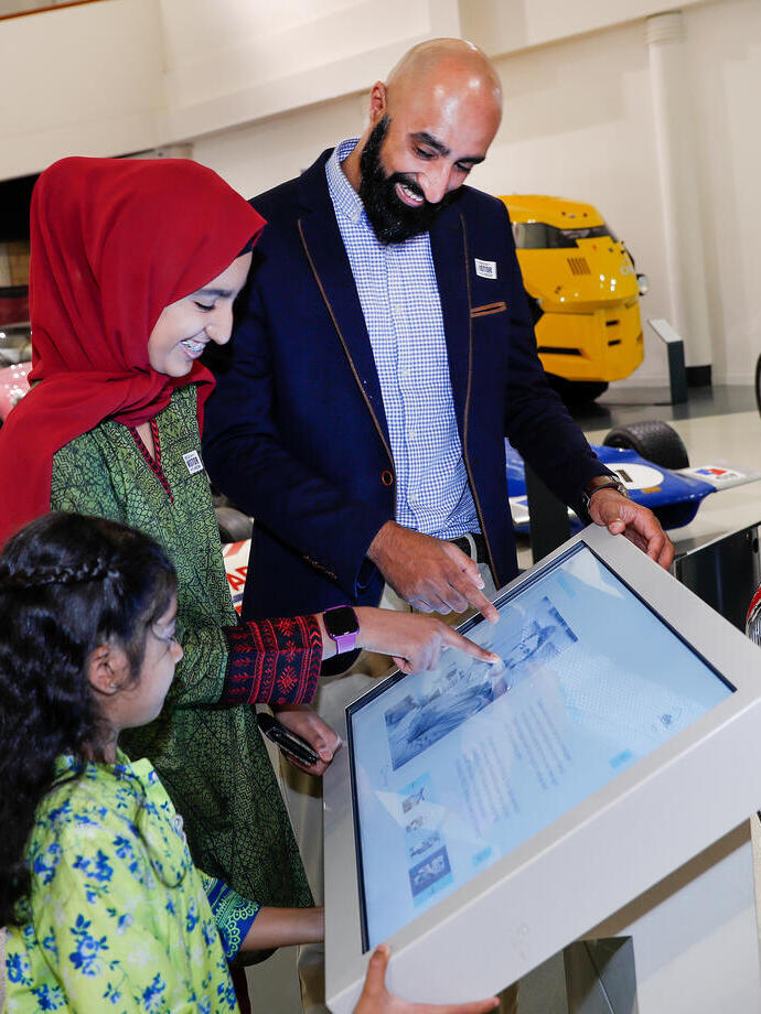 A family looking at an interactive exhibit at the British Motor Museum