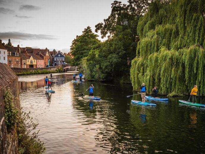 Un groupe de personnes faisant du paddleboard sur la rivière Wensum