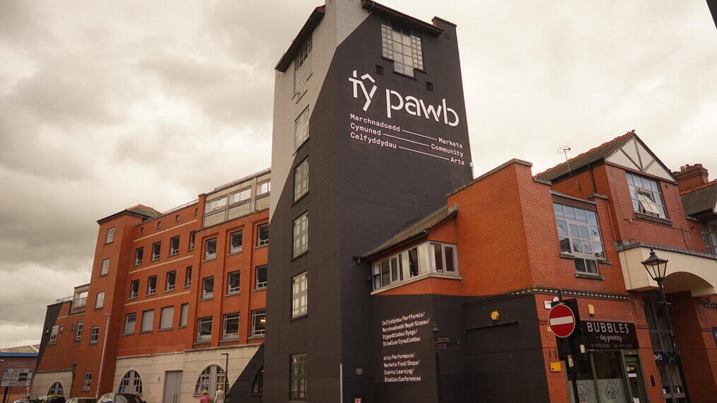 Außenansicht eines Gebäudes mit einem Schild mit der Aufschrift „Ty Pawb”.