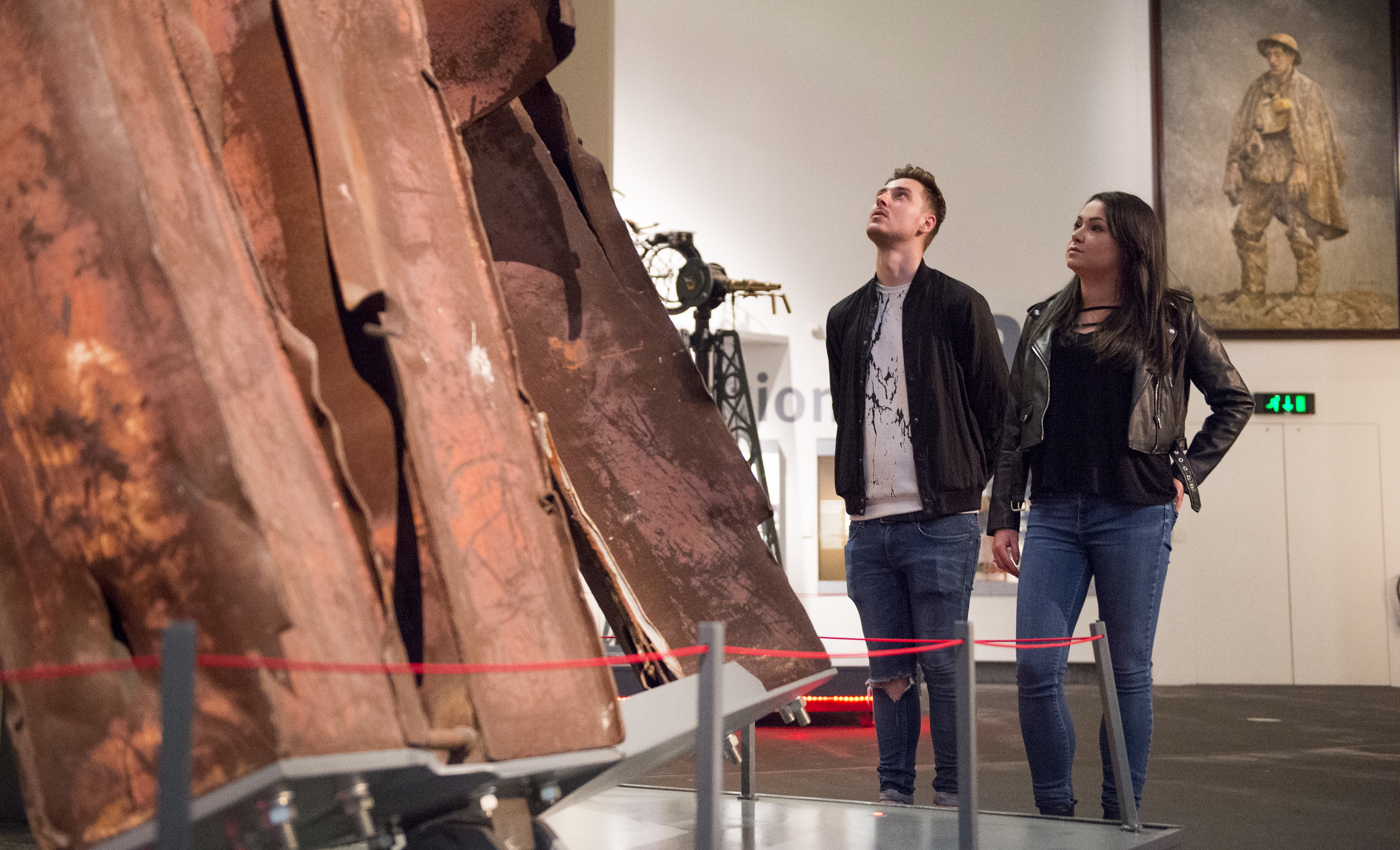 Two people looking upwards at an exhibit in Manchester Imperial War Museum