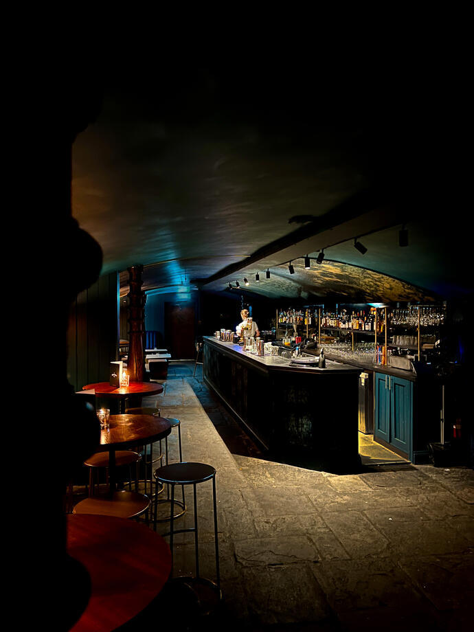 Inside a low lit cavernous empty bar.