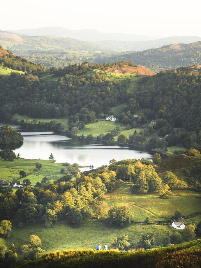 View from above of green rolling hills and a lake nearby