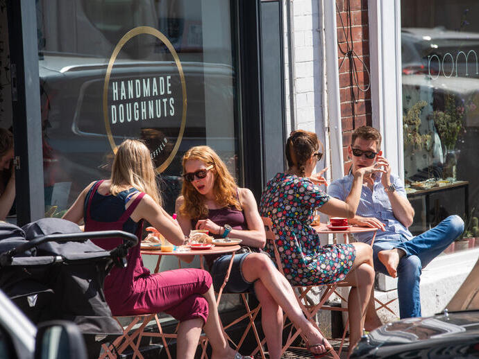 Grupos de personas sentadas fuera de Handmade Doughnuts en Sheffield