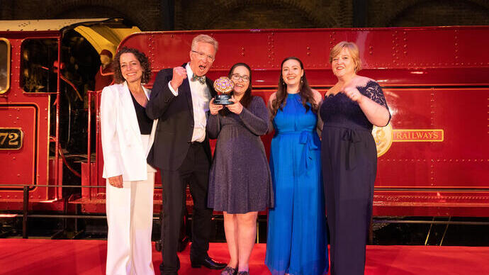 Photo of Gold Award Winners for the Accessible & Inclusive Tourism Award at the VisitEngland Awards for Excellence 2023 - Noah's Ark Zoo Farm (Representatives from Noah's Ark Zoo Farm, VisitEngland Director of HR and Professional Services Debra Lang, Relationship Director for Hospitality & Leisure at Corporate Banking Barclays Andy Mayne, Compere Alex Polizzi) - in front of the Hogwarts Express on stage