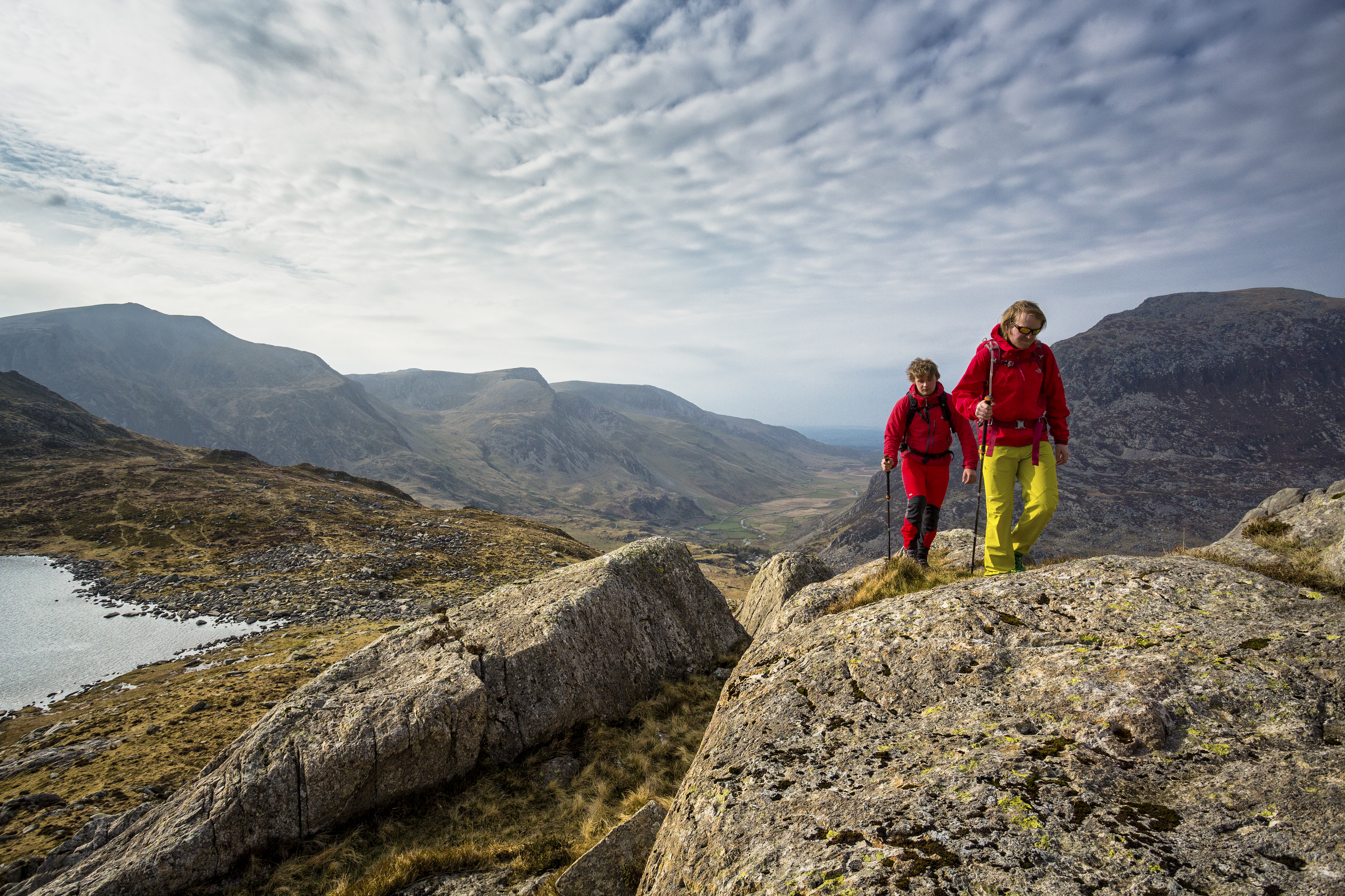Two people walking to the high pass through the mountains