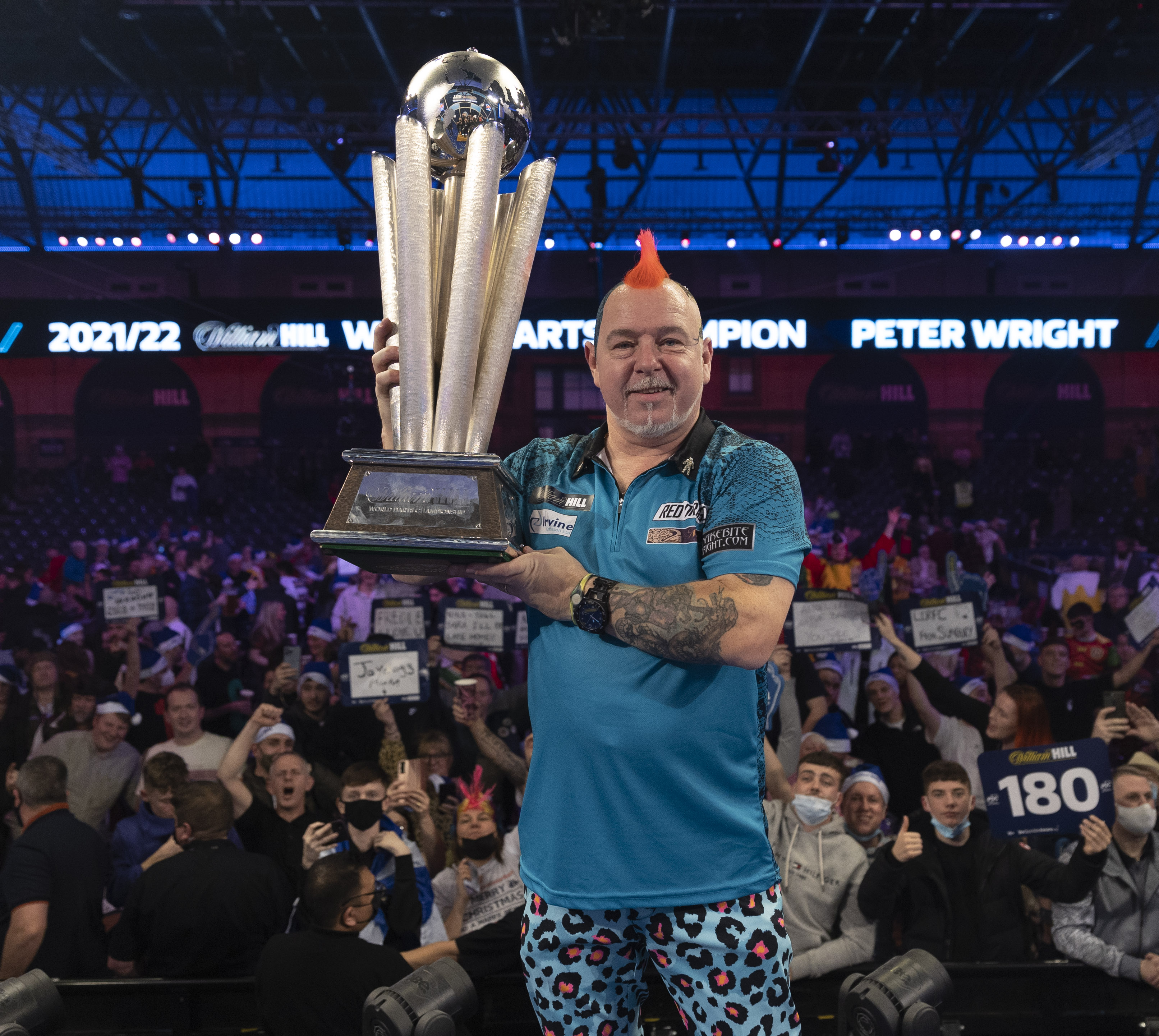 Homme tenant un trophée au championnat du monde de fléchettes