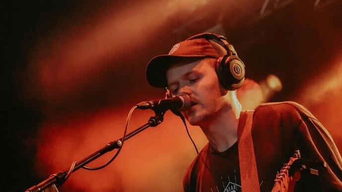Un uomo sul palco che canta e suona la chitarra all'Hebridean Celtic Festival