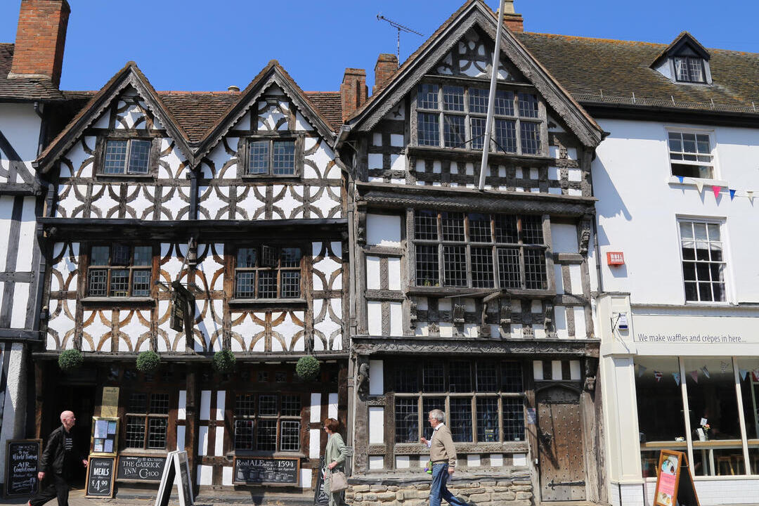 Street level view from across the street of pedestrians walking by The Garrick Inn, a half timbered frame 16th Century building in Stratford Upon Avon, ruputed to be Stratford's oldest pub.