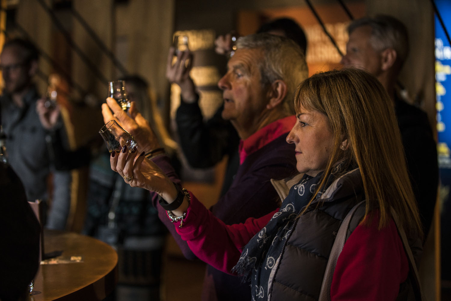 Group of people viewing glasses of whisky at Talisker Distillery