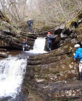 Children using a zipline across a waterfall at Alternative Adventure in Lancashire